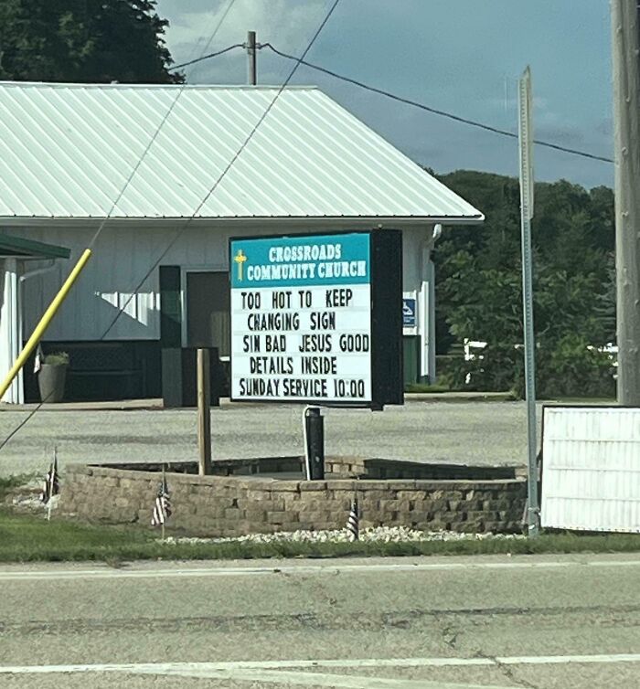 Church sign humorously referencing heatwaves, saying it's too hot to keep changing the message, highlighting extreme heat conditions.