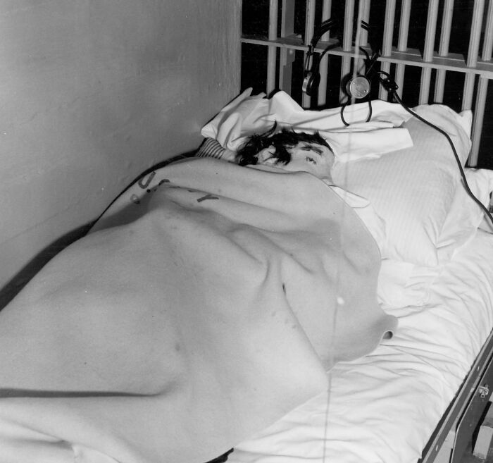 Inmate resting on a bed inside an Alcatraz prison cell, showing the harsh reality of life on Alcatraz.