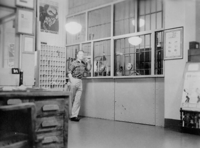 Man standing in a vintage Alcatraz prison office area, showing a rare glimpse into harsh reality of life on Alcatraz.