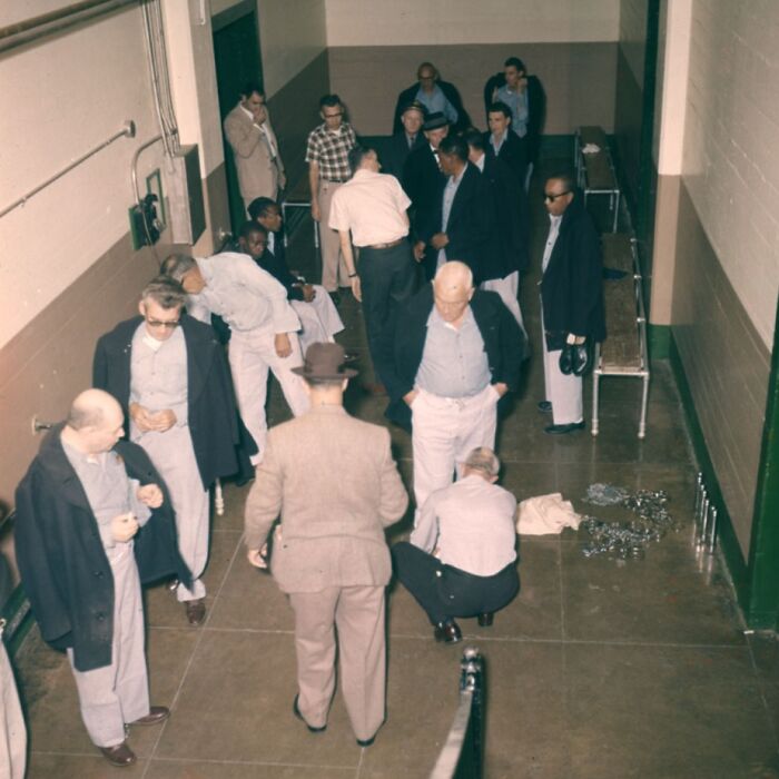 Group of inmates and a guard inside a prison corridor, showing a rare glimpse into the harsh reality of life on Alcatraz.