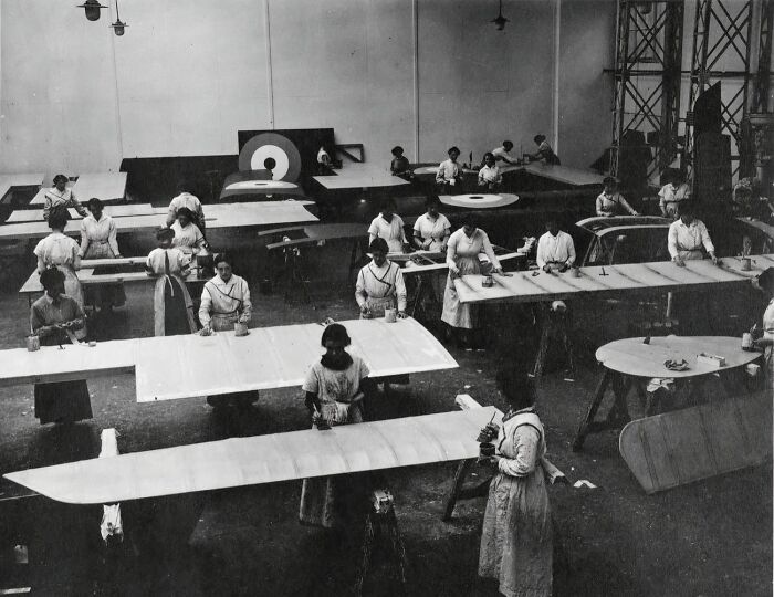 Women workers in WWI aircraft factory painting plane wings, highlighting how women changed everything during the war.