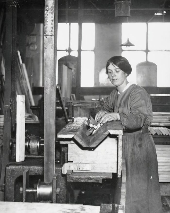 Woman working with woodworking tools in a factory, showcasing how women changed everything during WWI with industrial work.