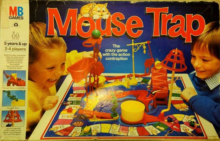 Two children excitedly playing the nostalgic Mouse Trap board game, evoking memories of old age and childhood fun.