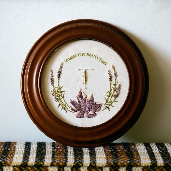 Circular wooden frame with beautiful embroidery of lavender flowers and crystals, showcasing impressive embroidery skills.