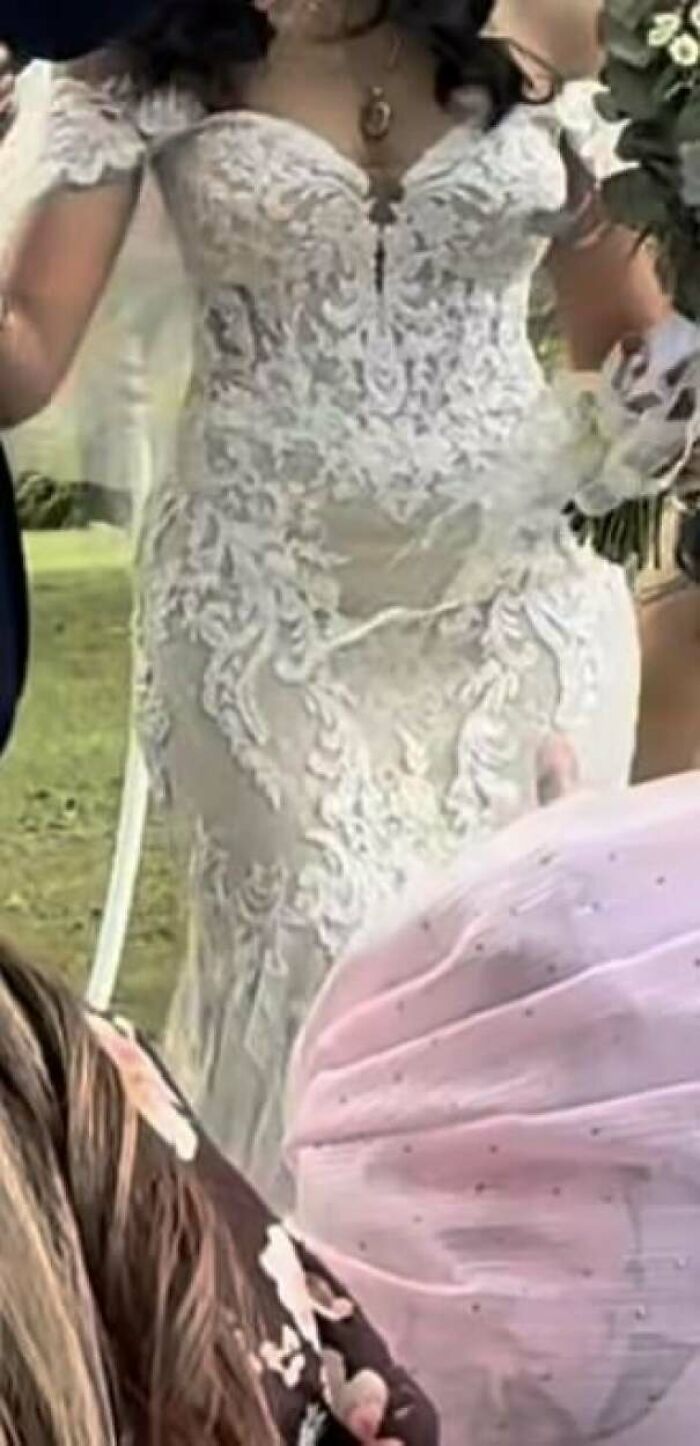 Bride wearing a detailed lace wedding dress posing outdoors, highlighting wedding guests and wedding moments.
