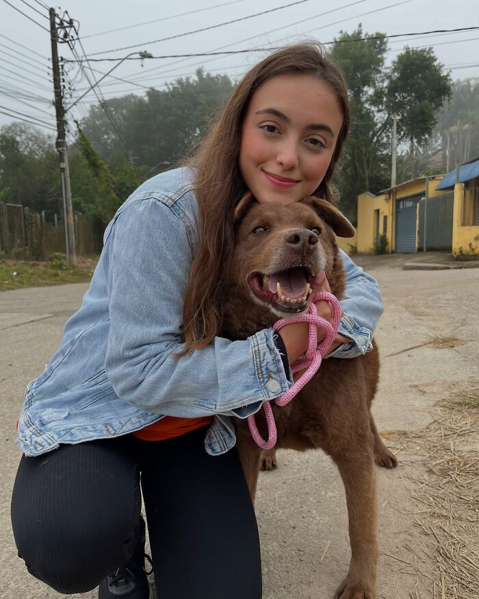 Young woman hugging a happy shelter dog on their weekly walk, capturing the pure joy of shelter dogs outdoors.