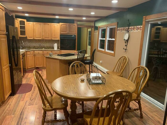 90s nostalgic kitchen interior with wooden cabinets and dining table