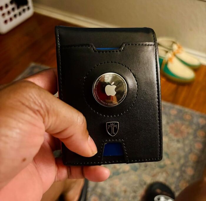 Hand holding a black leather wallet with an Apple AirTag holder, trending and add to cart worthy finds on Amazon this week.