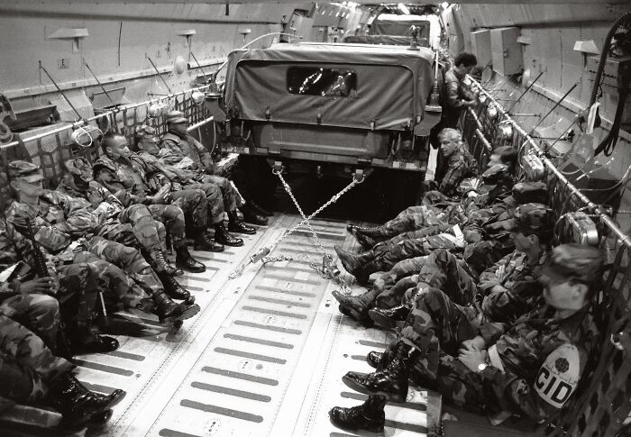Military personnel seated inside transport aircraft with vehicle secured, illustrating headlines that rocked the world in 2025.
