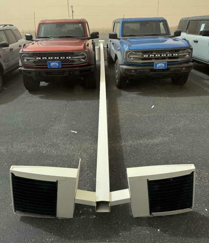 Two Broncos parked side by side with identical license plates, a rare coincidence in a parking lot.