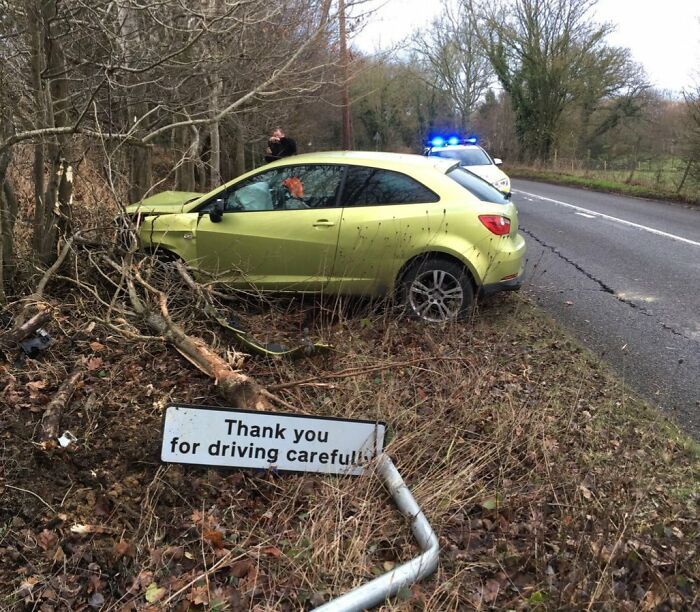 Car crash near a "Thank you for driving carefully" sign, showcasing a rare coincidence caught in a photo.