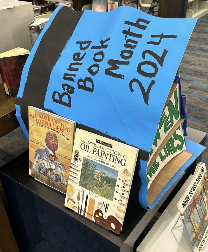 Display of banned books in a library with "Banned Book Month 2024" sign highlighting concerns about censorship and freedom.