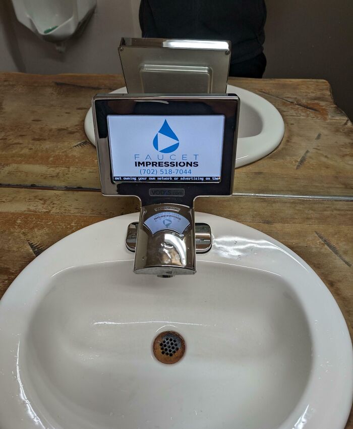 Rusty sink drain with a digital faucet screen displaying advertising, showcasing unusual photos that make you wonder about point of no return.