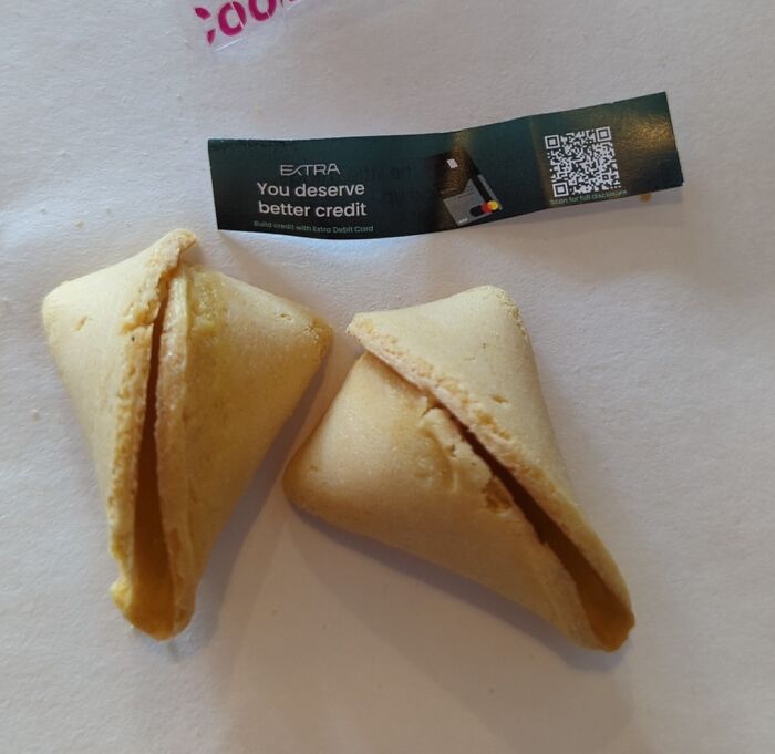 Two fortune cookies with a fortune strip on a white surface, illustrating photos that make you wonder point no return.