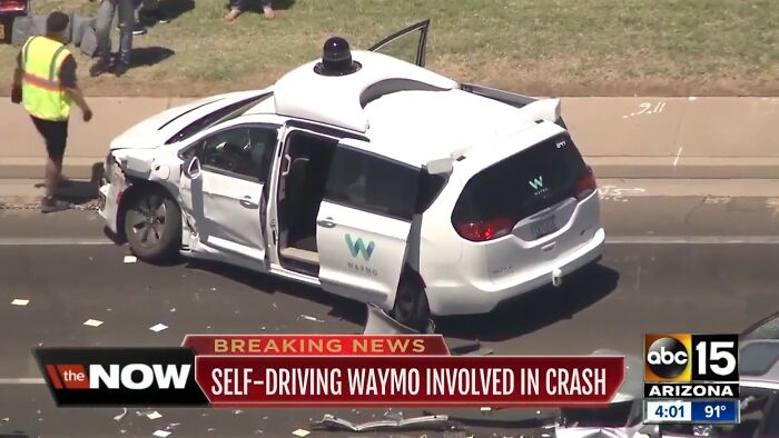 Damaged self-driving Waymo vehicle after crash on a city street, highlighting concerns about point of no return with autonomous cars.