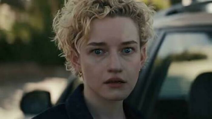 Close-up of a woman with curly blonde hair looking confused, representing bad movie details in an online group.