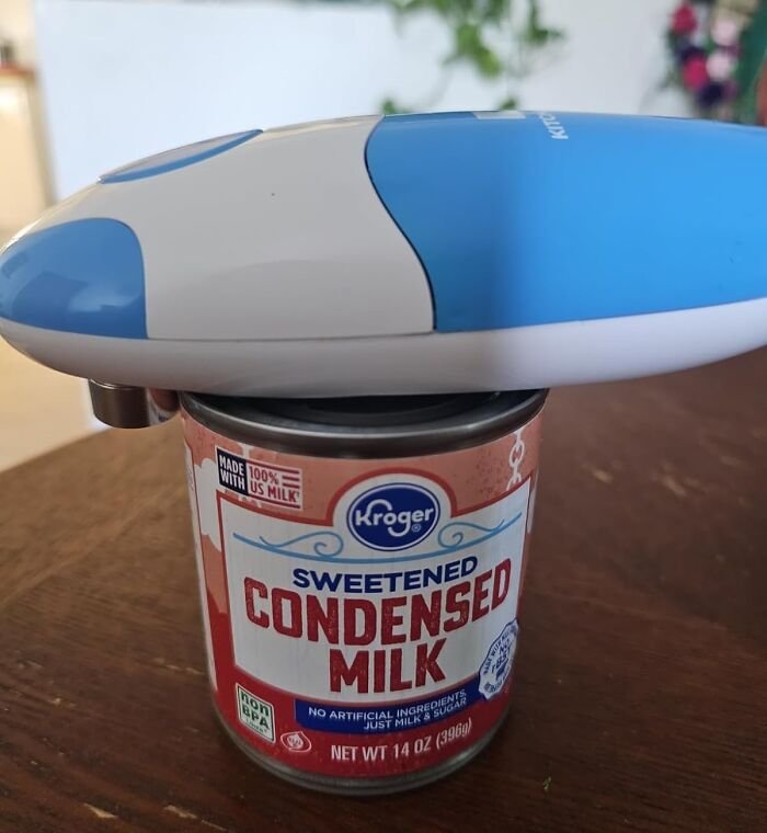 Electric can opener on a can of sweetened condensed milk, a dorm kitchen survival guide essential item.