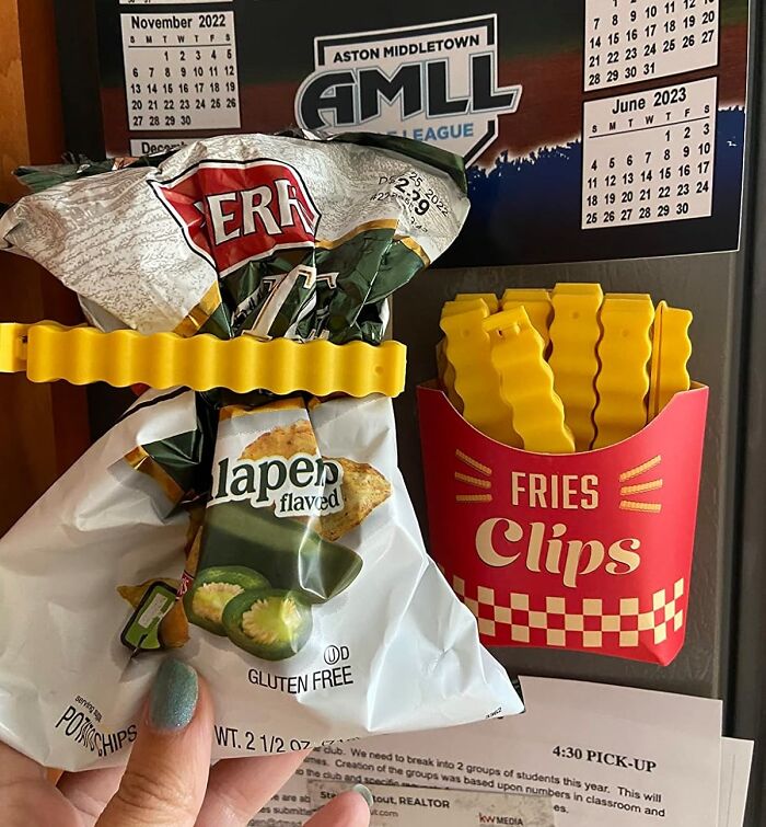 Yellow chip clips shaped like fries sealing a bag of jalapeno flavored chips on a fridge magnet.
