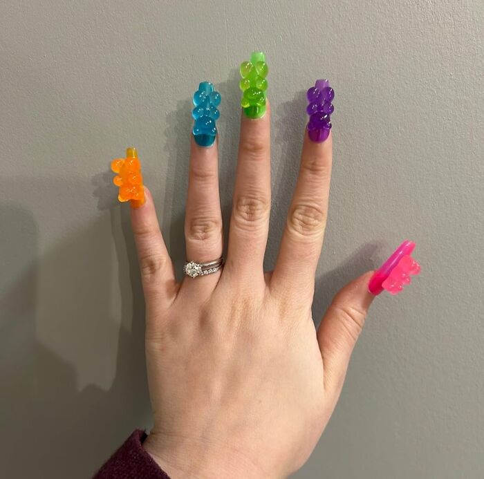 Hand with colorful gummy bear-shaped nail accessories showcasing an everyday item with a major personality upgrade.