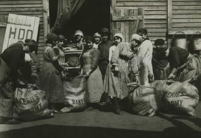 Group of women working with bakery supplies during daily life beyond the WWI trenches in a wartime setting.