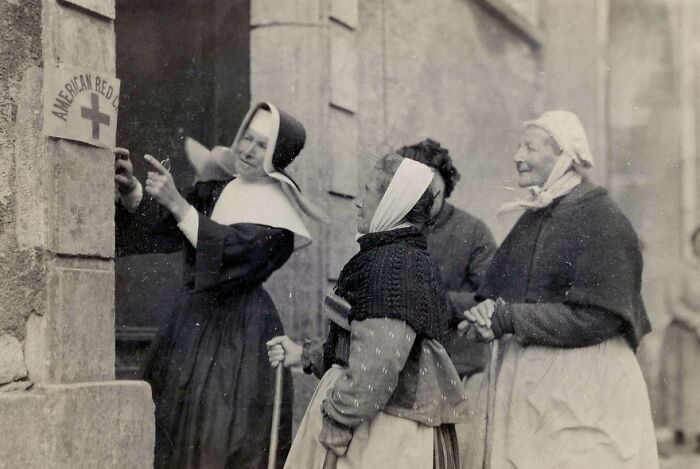 Nurses and women outside a building during WWI, showcasing daily life beyond the WWI trenches in a historic moment.