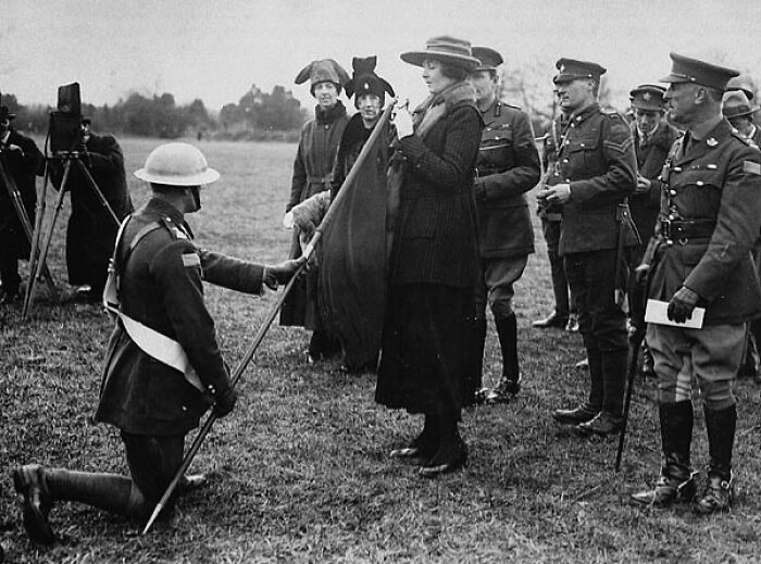 Soldier kneeling before a woman with a horse outdoors, showcasing daily life beyond the WWI trenches in a historical scene.