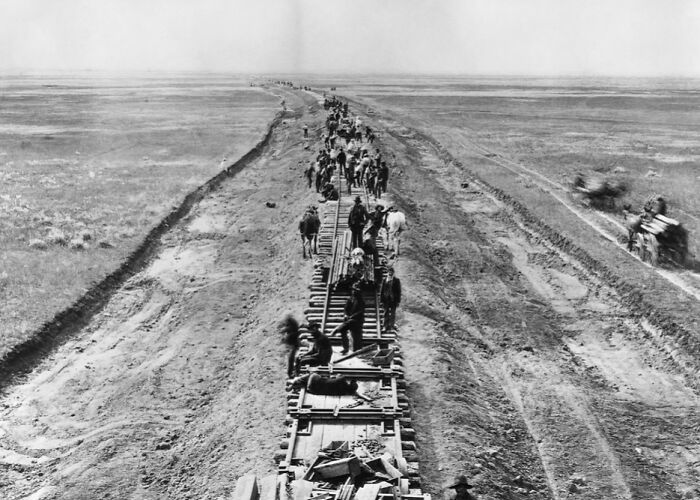 Construction workers building a railroad track in 1800s America, showcasing the real story of expansion and labor.