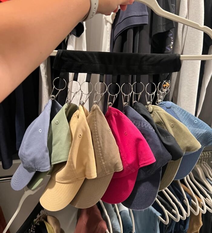 Hanging organizer maximizing awkward nook storage by neatly holding multiple hats on keyring clips in a dorm closet.