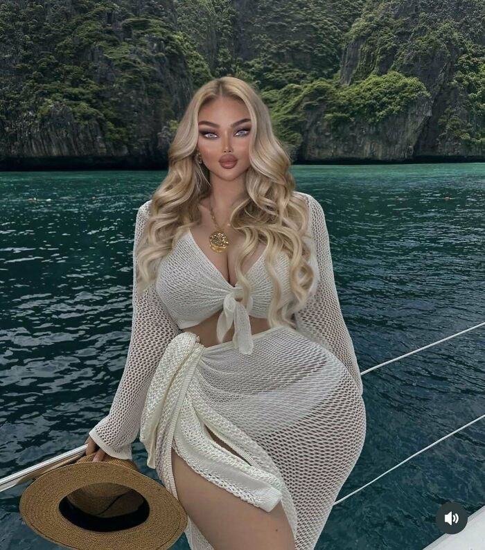 Woman with long blonde hair in a white mesh outfit holding a hat on a boat showing Instagram vs reality contrast.