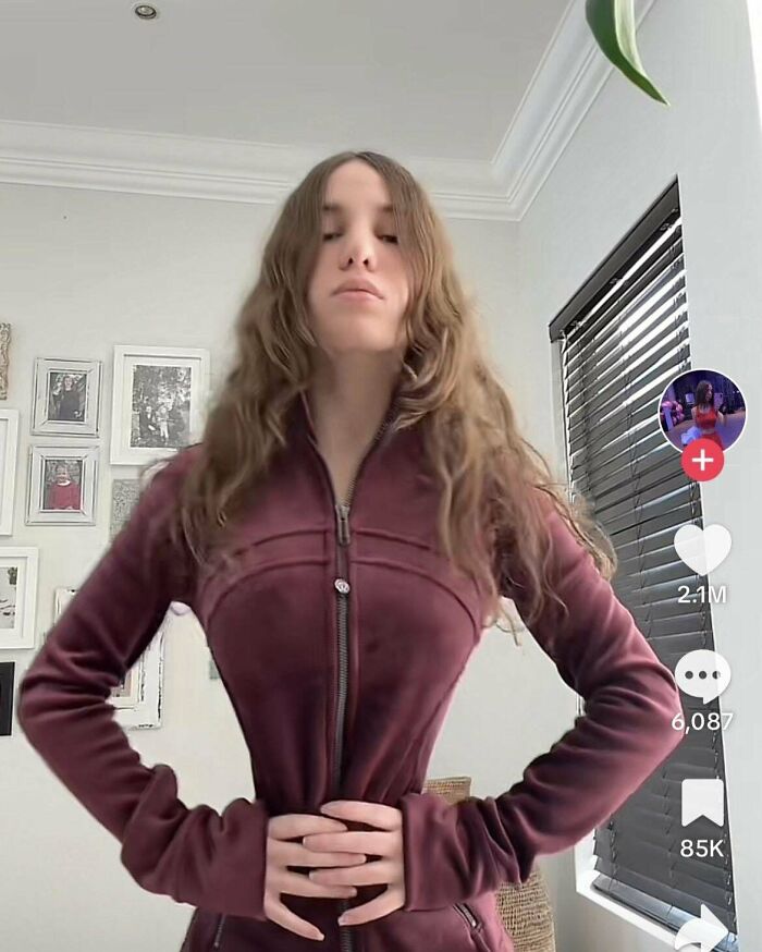 Young woman in a maroon zip-up jacket posing indoors, illustrating Instagram vs reality pics and social media perceptions.