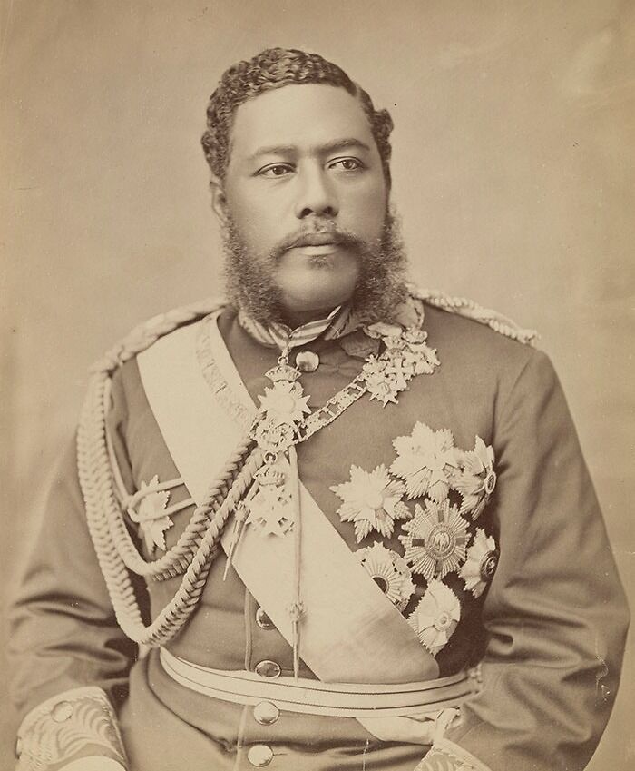 Sepia historical photo of a man in military uniform adorned with medals and ceremonial sash, a rare historical photo.