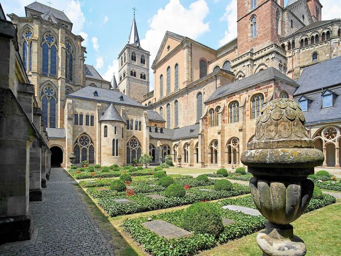 A beautiful example of architecture featuring an ancient European cathedral with a serene courtyard garden.
