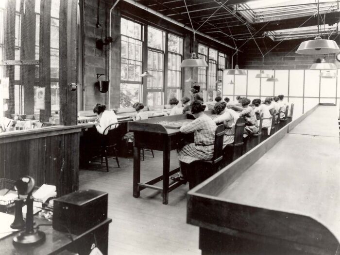 Black and white historical photo showing women working together in a large room, illustrating unusual historical photos.