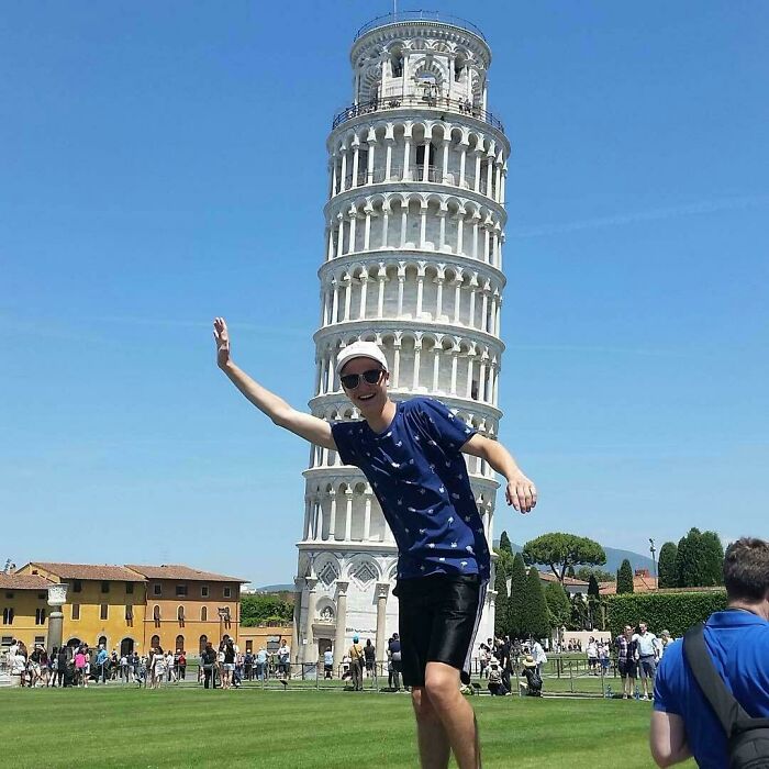 Person posing humorously in front of the Leaning Tower of Pisa, showing funny ways people learned their lesson.