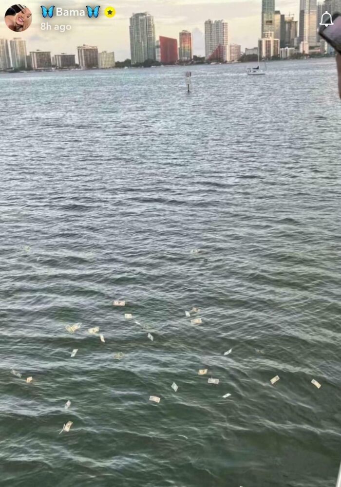 Bills floating in a large body of water near a city skyline, showing a disregard for rules and etiquette.