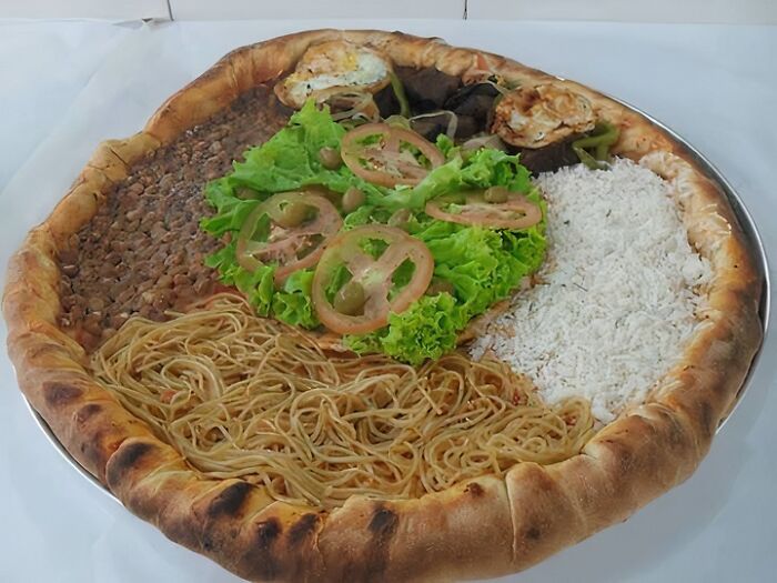 Large baked dish with pasta, rice, beans, and salad on a crust, illustrating food nobody should eat for health.