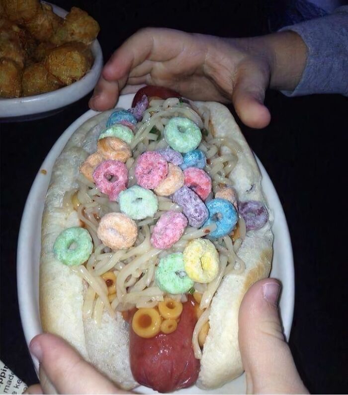 Unusual food combination of hot dog, spaghetti, and colorful cereal illustrating food nobody should eat for health.