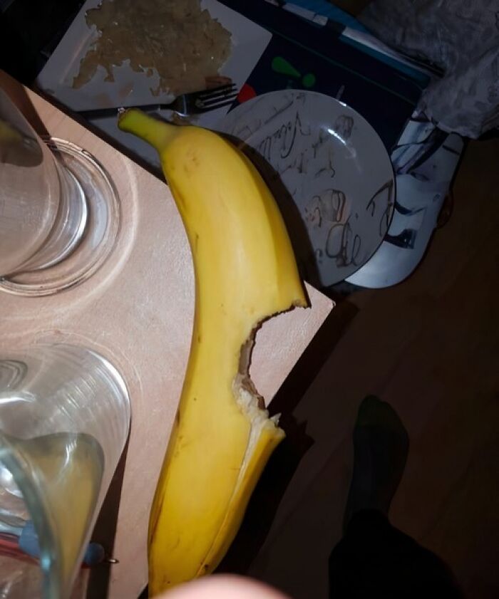 Partially eaten banana placed on a table with dishes nearby, highlighting food nobody should eat for health.