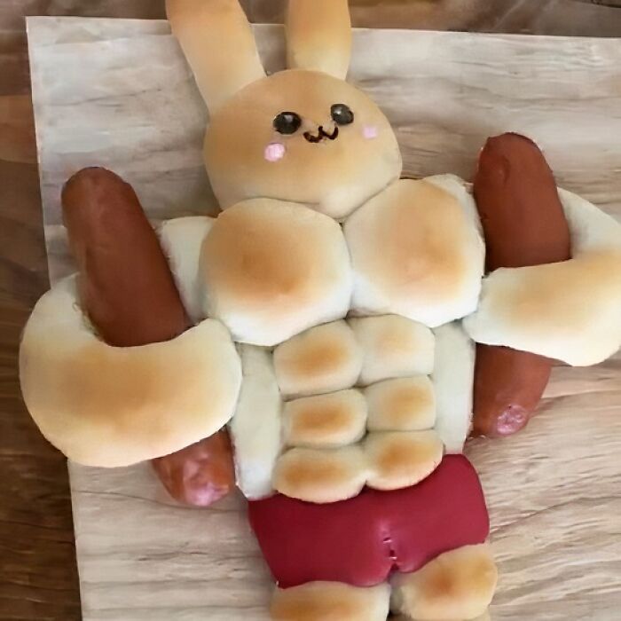 Bread shaped like a muscular bunny holding two sausages, representing food nobody should eat for physical and mental health.