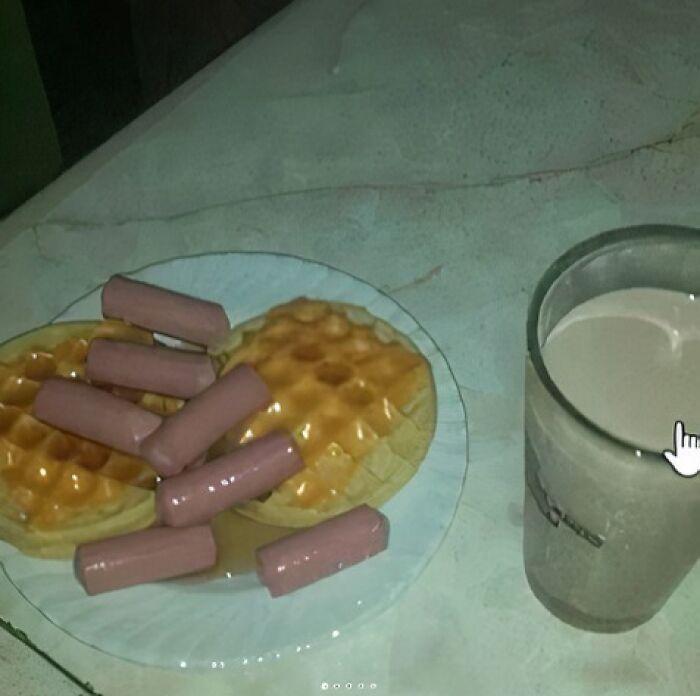 Plate with waffles topped with hot dogs and syrup next to a glass of milk, illustrating food to avoid for health.