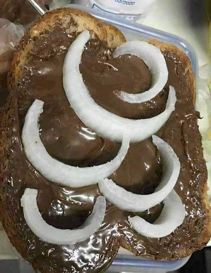Slice of bread topped with chocolate spread and raw onion, an example of food nobody should eat for health reasons