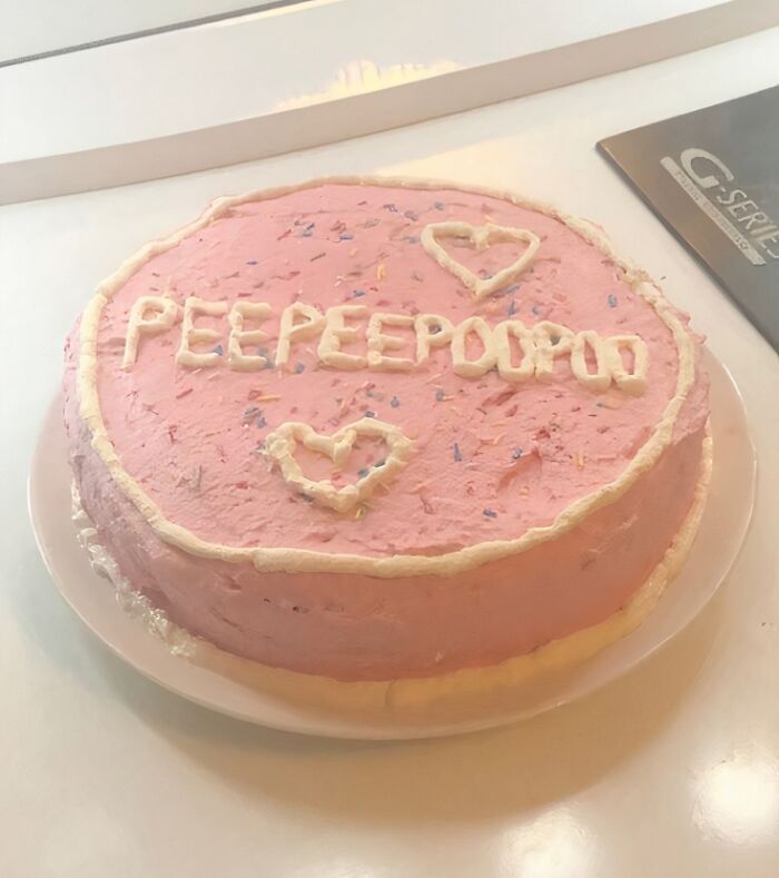Round pink frosted cake with white icing and decorative hearts, an example of food nobody should eat for health reasons.