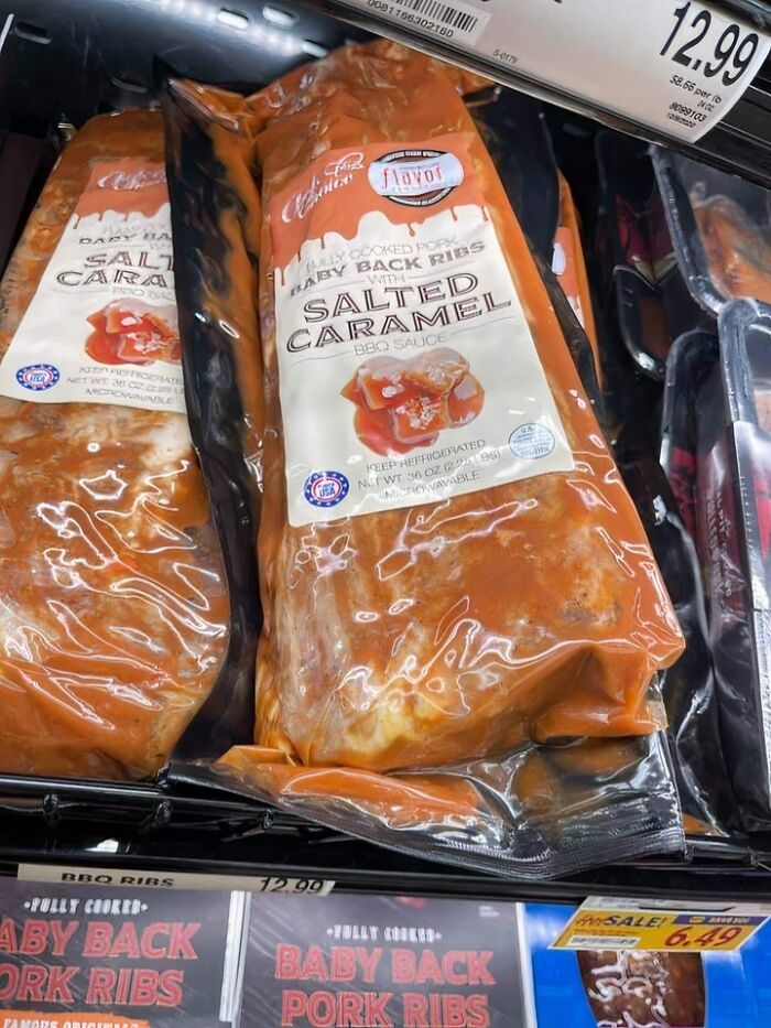 Packaged baby back ribs with salted caramel BBQ sauce displayed in a refrigerated grocery store section.