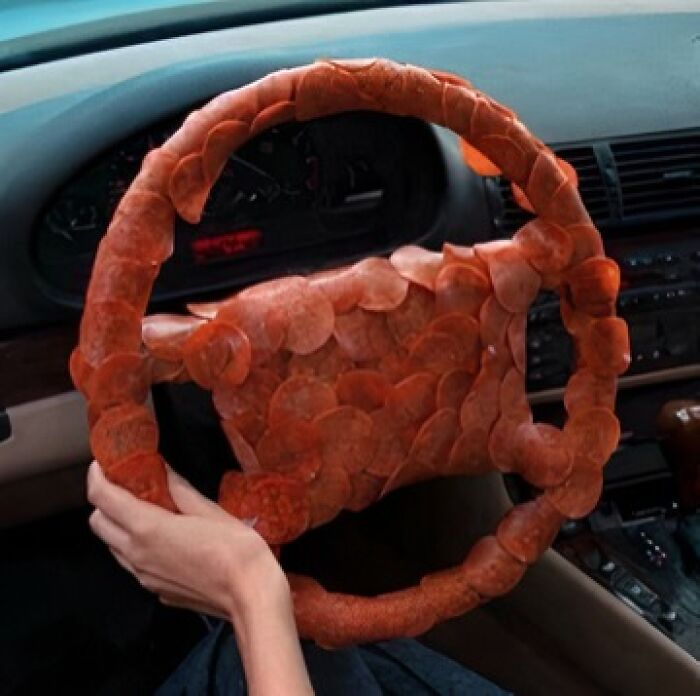 Steering wheel covered entirely with slices of pepperoni, illustrating unusual food nobody should eat risks.