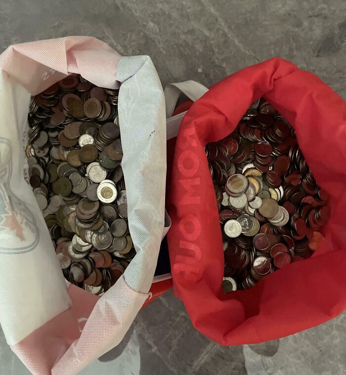 Two large bags filled with mixed coins placed on a tiled floor, illustrating disregard for rules and etiquette.