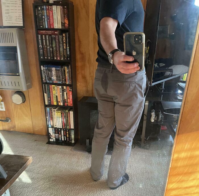 Man taking mirror selfie showing wet stain on pants, illustrating funny ways people learned their lesson humorously at home.