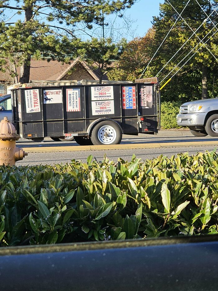 Trailer with various political signs parked on a street, showing attempts with unexpected universe plans.