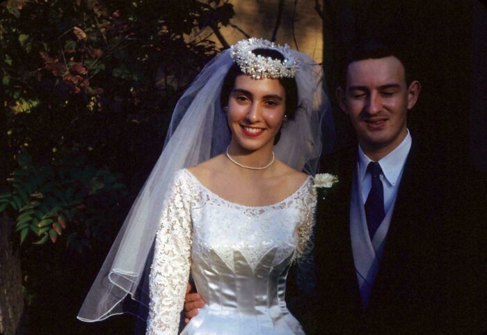 Bride and groom posing outdoors in candid glimpses into the past, showcasing vintage wedding attire and joyful expressions