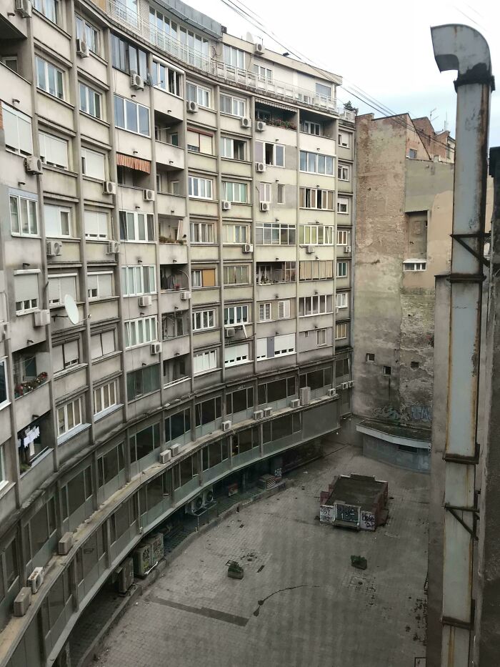 Dilapidated urban apartment buildings in a neglected courtyard, illustrating urban hell and societal decay in the cityscape.