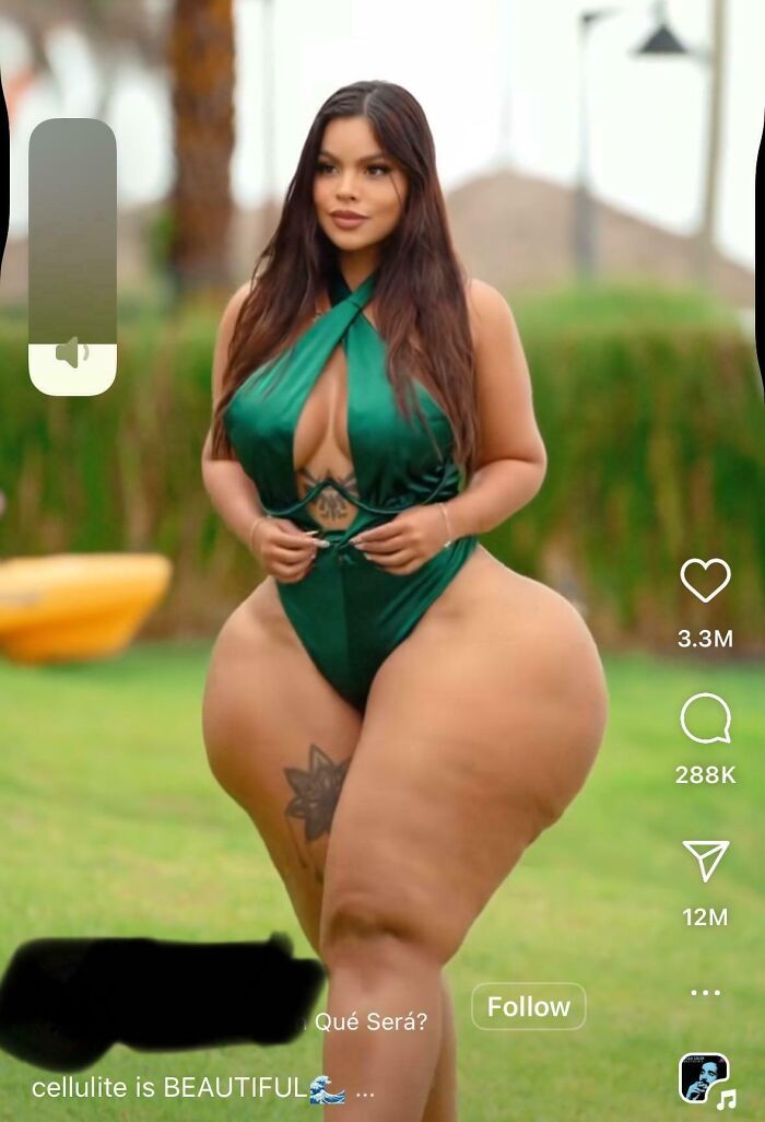 Woman in green swimsuit posing outdoors showing cellulite, highlighting Instagram vs reality pics on social media.